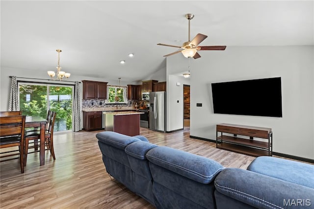111 Rivers Edge Dr, Moscow Mills, MO 63362 - living room featuring a chandelier, a ceiling fan, vaulted ceiling, and light wood finished floors