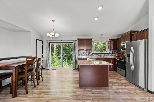 111 Rivers Edge Dr, Moscow Mills, MO 63362 - kitchen with appliances with stainless steel finishes, lofted ceiling, a kitchen island, backsplash, and a chandelier