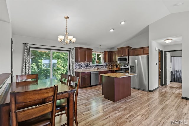111 Rivers Edge Dr, Moscow Mills, MO 63362 - kitchen with stainless steel appliances, lofted ceiling, a center island, a chandelier, and backsplash