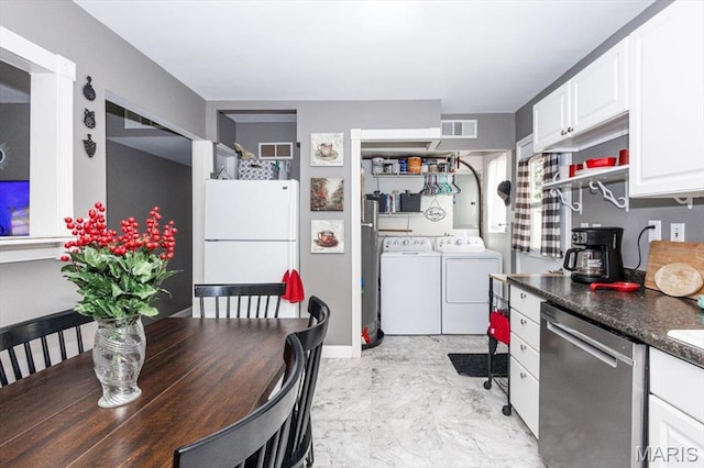 314 Weber Dr, Eureka, MO 63025 - kitchen featuring stainless steel dishwasher, separate washer and dryer, freestanding refrigerator, white cabinetry, and dark countertops