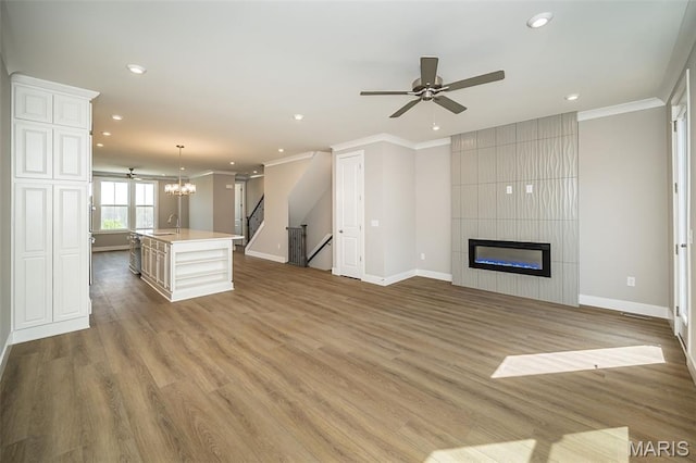 8915 E Gateway Hts Unit 94-803, Richmond Heights, MO 63144 - unfurnished living room featuring ornamental molding, stairway, recessed lighting, a chandelier, and a fireplace