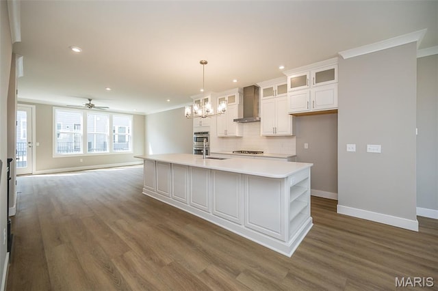 8915 E Gateway Hts Unit 94-803, Richmond Heights, MO 63144 - kitchen featuring wall chimney range hood, dark wood-type flooring, gas stovetop, white cabinets, and light countertops