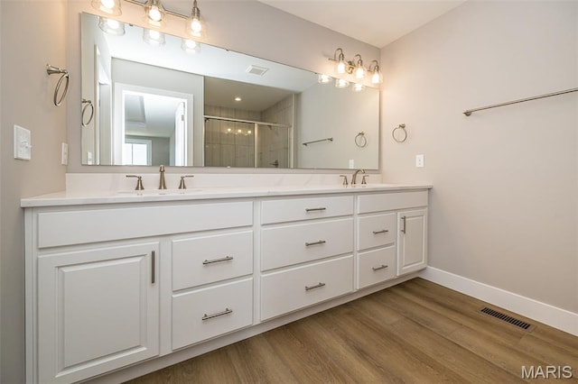 8915 E Gateway Hts Unit 94-803, Richmond Heights, MO 63144 - bathroom with a stall shower, double vanity, and wood finished floors