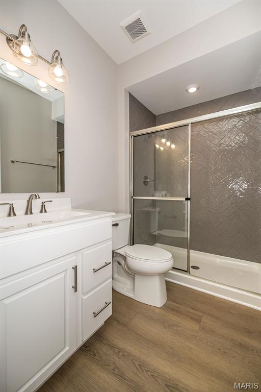 8915 E Gateway Hts Unit 94-803, Richmond Heights, MO 63144 - bathroom with vanity, a stall shower, and wood finished floors