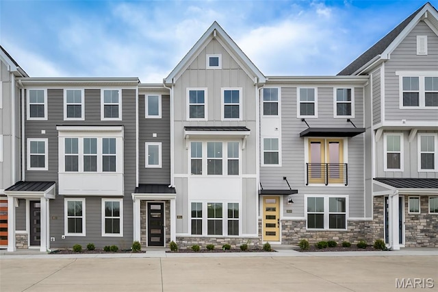 8915 E Gateway Hts Unit 94-803, Richmond Heights, MO 63144 - townhome / multi-family property with a standing seam roof, board and batten siding, stone siding, and a metal roof