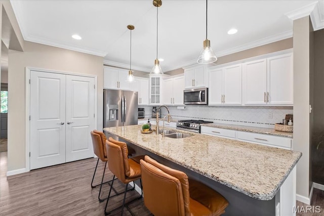 2385 Chemin Ave, Saint Charles, MO 63301 - kitchen with appliances with stainless steel finishes, white cabinetry, decorative backsplash, dark wood-style flooring, and a breakfast bar area