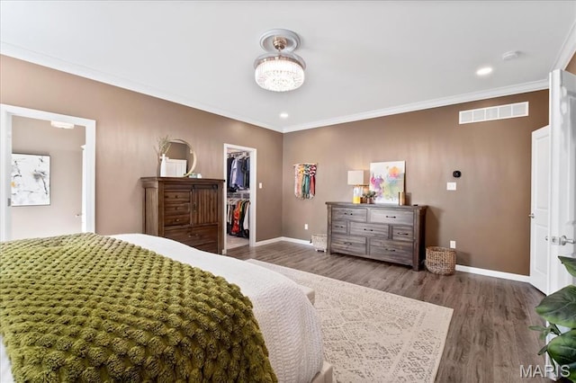 2385 Chemin Ave, Saint Charles, MO 63301 - bedroom with a walk in closet, wood finished floors, ornamental molding, a closet, and recessed lighting