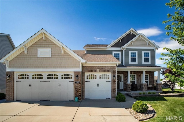 2385 Chemin Ave, Saint Charles, MO 63301 - craftsman house featuring a garage, driveway, brick siding, and covered porch