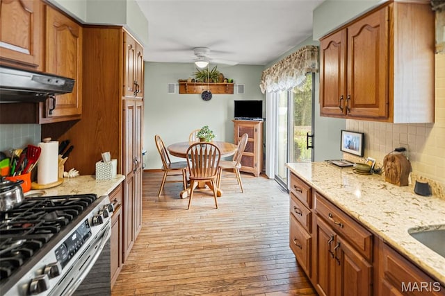 3200 Ridgeway Ave, Godfrey, IL 62035 - kitchen featuring stainless steel gas stove, light wood-type flooring, tasteful backsplash, ceiling fan, and light stone countertops