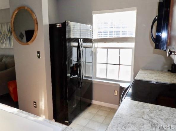7302 Spring Creek Ln, Ofallon, MO 63368 - kitchen with black appliances, light countertops, and light tile patterned floors