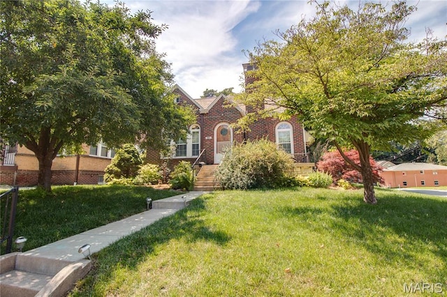 301 E 7th St, Alton, IL 62002 - tudor-style house with a front yard and brick siding