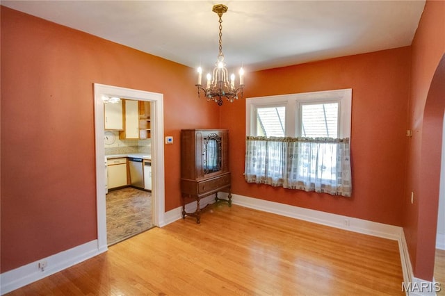 301 E 7th St, Alton, IL 62002 - spare room featuring light wood finished floors, a chandelier, and arched walkways