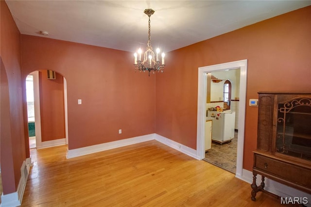 301 E 7th St, Alton, IL 62002 - unfurnished dining area with arched walkways, light wood finished floors, and a chandelier