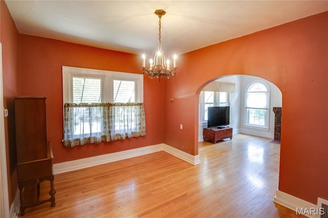 301 E 7th St, Alton, IL 62002 - empty room with arched walkways, light wood-style floors, and a chandelier