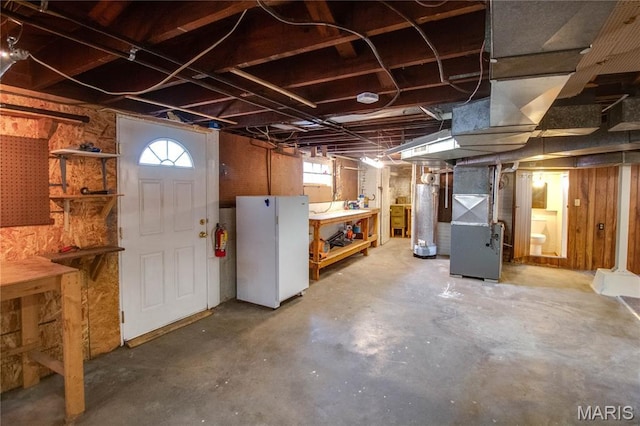 301 E 7th St, Alton, IL 62002 - below grade area with freestanding refrigerator, a workshop area, heating unit, and water heater