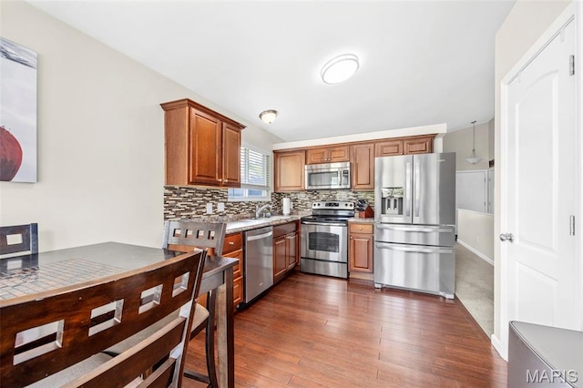33 Kingspointe Dr, Saint Peters, MO 63376 - kitchen with appliances with stainless steel finishes, dark wood-style floors, decorative backsplash, and brown cabinetry