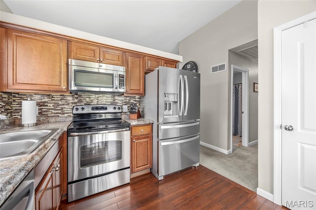 33 Kingspointe Dr, Saint Peters, MO 63376 - kitchen with appliances with stainless steel finishes, decorative backsplash, and brown cabinetry
