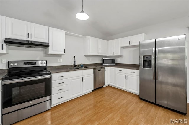 5265 Country Club Rd, Washington, MO 63090 - kitchen with stainless steel appliances, under cabinet range hood, dark countertops, light wood-type flooring, and white cabinetry