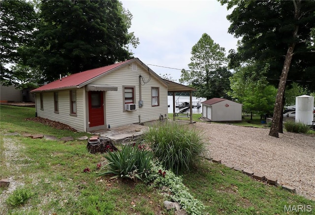 980 Laura Hufferd Rd, Roach, MO 65787 - view of front facade featuring cooling unit, driveway, a metal roof, a front lawn, and a storage shed