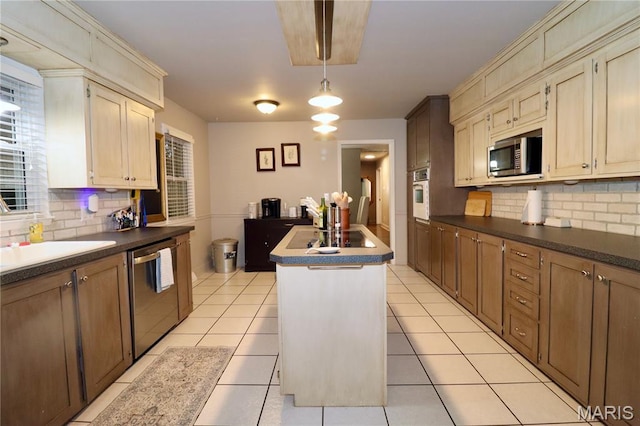 110 S Bend Rd, Lebanon, MO 65536 - kitchen with appliances with stainless steel finishes, a kitchen island with sink, tasteful backsplash, and dark countertops