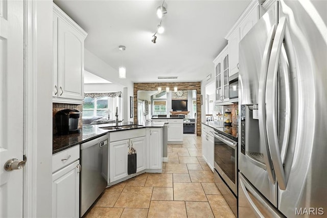 2039 Meramec Meadows Dr, Fenton, MO 63026 - kitchen with stainless steel appliances, a peninsula, dark countertops, and white cabinetry