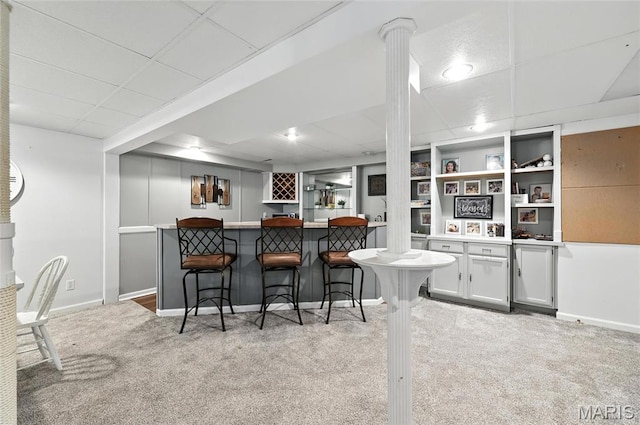 2039 Meramec Meadows Dr, Fenton, MO 63026 - kitchen featuring light colored carpet, a paneled ceiling, a breakfast bar, white cabinets, and light countertops