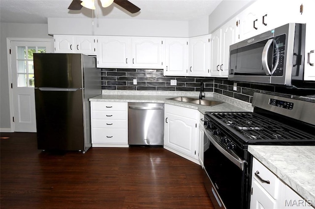 1100 Ozment Dr, Florissant, MO 63033 - kitchen featuring appliances with stainless steel finishes, ceiling fan, dark wood-style flooring, and tasteful backsplash