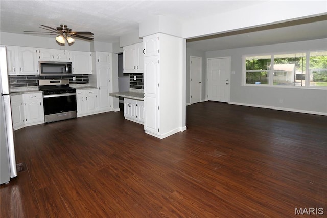 1100 Ozment Dr, Florissant, MO 63033 - kitchen featuring appliances with stainless steel finishes, backsplash, and white cabinetry
