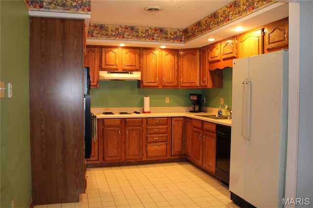 904 Keith St, Kennett, MO 63857 - kitchen featuring freestanding refrigerator, under cabinet range hood, dishwasher, light countertops, and brown cabinetry