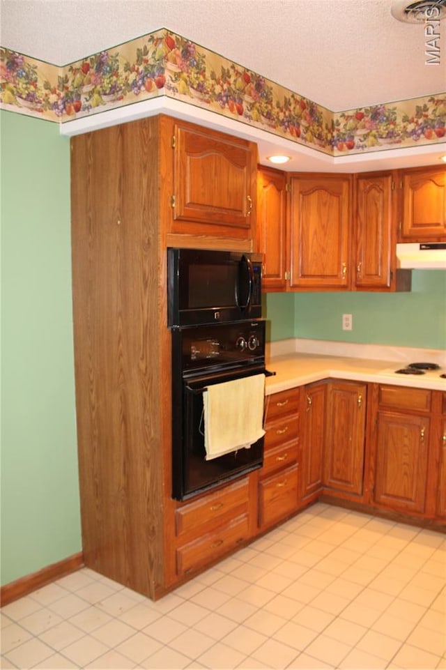 904 Keith St, Kennett, MO 63857 - kitchen featuring black appliances, under cabinet range hood, a textured ceiling, light countertops, and brown cabinets