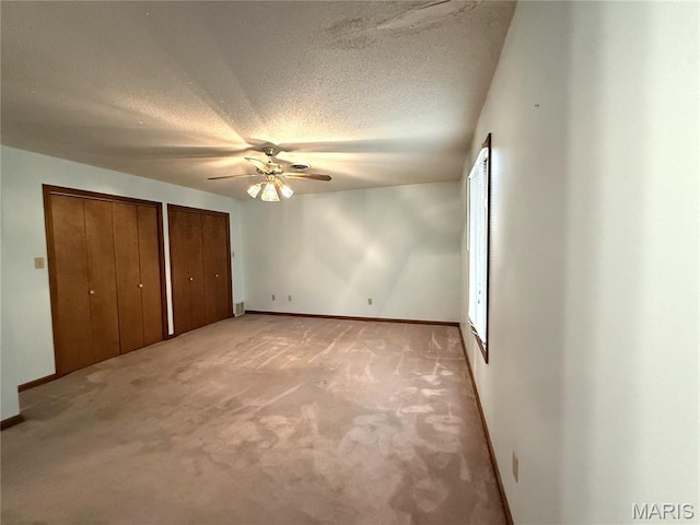 904 Keith St, Kennett, MO 63857 - unfurnished bedroom with multiple closets, light carpet, a textured ceiling, and ceiling fan