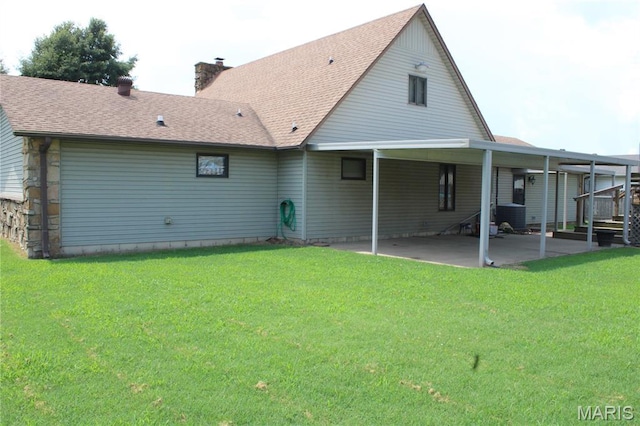 904 Keith St, Kennett, MO 63857 - back of property with a lawn, a chimney, a patio area, and a shingled roof