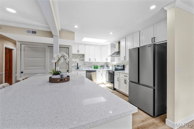 115 E Bodley Ave Unit A6, Kirkwood, MO 63122 - kitchen featuring stainless steel appliances, wall chimney exhaust hood, backsplash, white cabinetry, and light stone counters