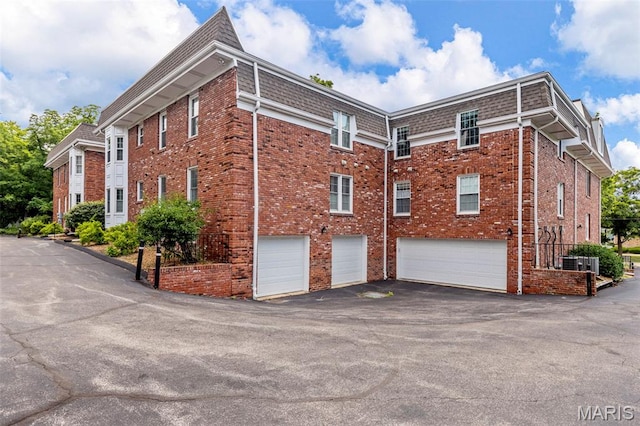 115 E Bodley Ave Unit A6, Kirkwood, MO 63122 - view of side of home with a garage, brick siding, and driveway