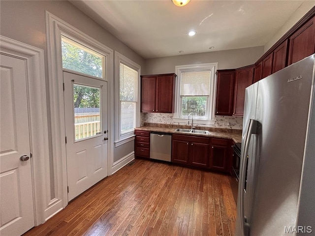2012 Mallinckrodt St, Saint Louis, MO 63107 - kitchen featuring stainless steel appliances, dark wood-style flooring, decorative backsplash, and dark countertops