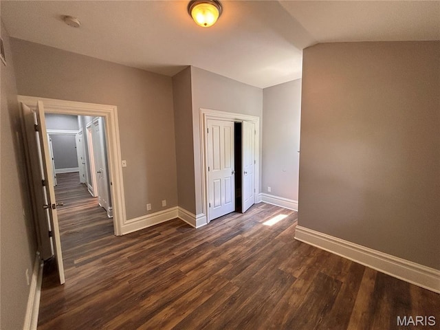 2012 Mallinckrodt St, Saint Louis, MO 63107 - unfurnished bedroom featuring dark wood finished floors, a closet, and vaulted ceiling