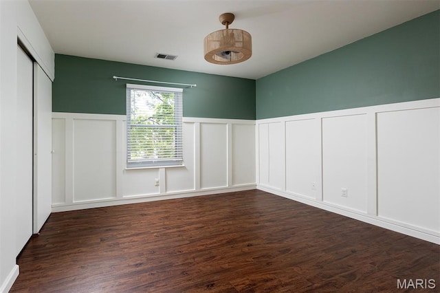 1316 Holgate Unit G6, Ballwin, MO 63021 - spare room featuring a decorative wall, dark wood-type flooring, and a wainscoted wall