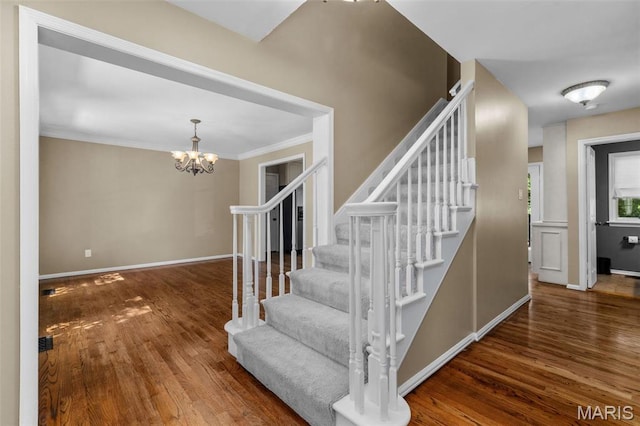 15495 Long Castle Forest Ct, Chesterfield, MO 63017 - stairway featuring wood finished floors, a chandelier, and ornamental molding