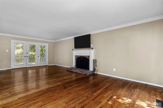15495 Long Castle Forest Ct, Chesterfield, MO 63017 - unfurnished living room featuring ornamental molding, a brick fireplace, wood finished floors, and french doors