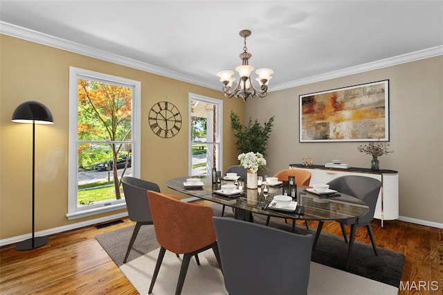 15495 Long Castle Forest Ct, Chesterfield, MO 63017 - dining area featuring crown molding, plenty of natural light, a chandelier, and wood finished floors