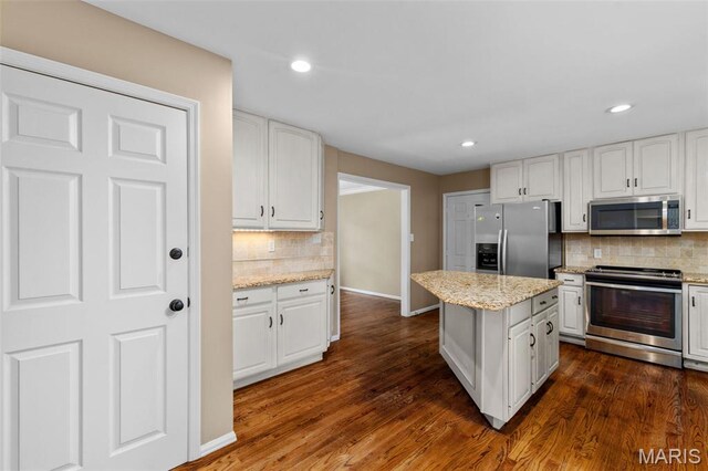15495 Long Castle Forest Ct, Chesterfield, MO 63017 - kitchen with stainless steel appliances, backsplash, white cabinets, a center island, and dark wood-style flooring