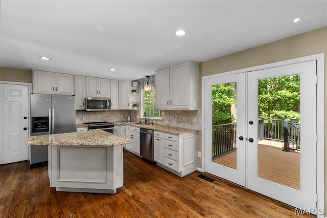 15495 Long Castle Forest Ct, Chesterfield, MO 63017 - kitchen featuring stainless steel appliances, backsplash, light stone counters, french doors, and recessed lighting