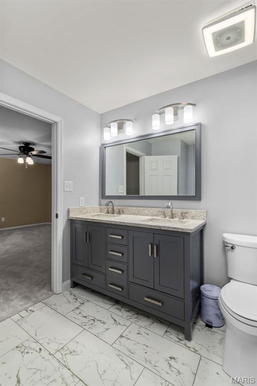 15495 Long Castle Forest Ct, Chesterfield, MO 63017 - bathroom featuring double vanity, marble finish floors, and ceiling fan
