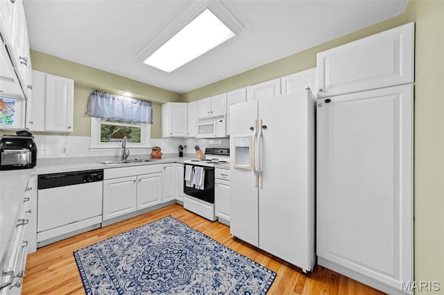 1745 Woodwind Dr, Imperial, MO 63052 - kitchen featuring white appliances, white cabinetry, light countertops, and light wood-style flooring