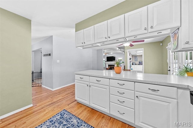 1745 Woodwind Dr, Imperial, MO 63052 - kitchen with ceiling fan, white cabinets, light countertops, and light wood-style floors