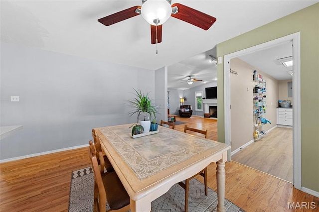 1745 Woodwind Dr, Imperial, MO 63052 - dining room featuring a ceiling fan, a fireplace, and light wood-style flooring