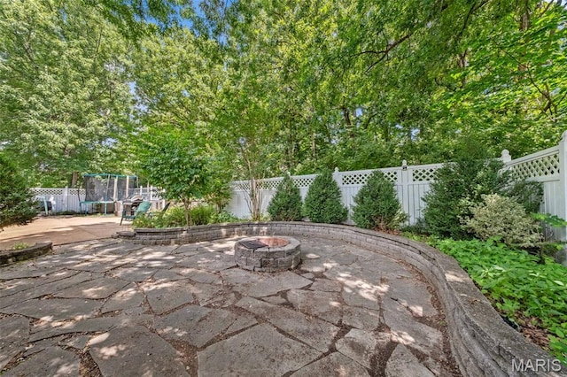 1745 Woodwind Dr, Imperial, MO 63052 - fenced backyard featuring a fire pit, a trampoline, and a patio