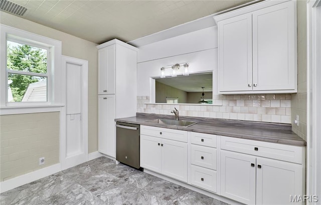 900 3rd St, Troy, MO 63379 - kitchen featuring stainless steel dishwasher, dark countertops, decorative backsplash, white cabinets, and light marble finish flooring