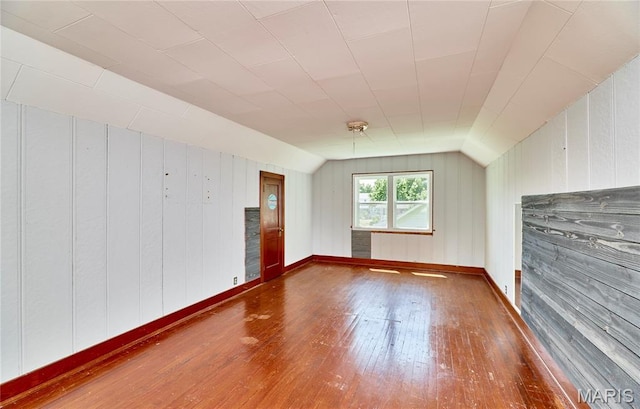 900 3rd St, Troy, MO 63379 - unfurnished living room featuring hardwood / wood-style floors, wood walls, and vaulted ceiling