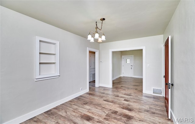 900 3rd St, Troy, MO 63379 - empty room featuring a chandelier, wood finished floors, and built in features